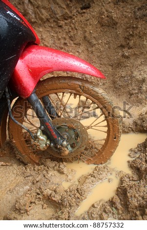 Motorbike front wheel on the wet dirty road. Laos