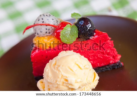 Cheese cake and  ice-cream on plate  with fruit topping.