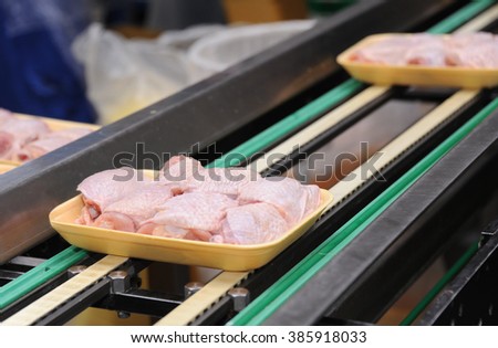 Fresh and raw chicken meat on conveyor belt in factory
