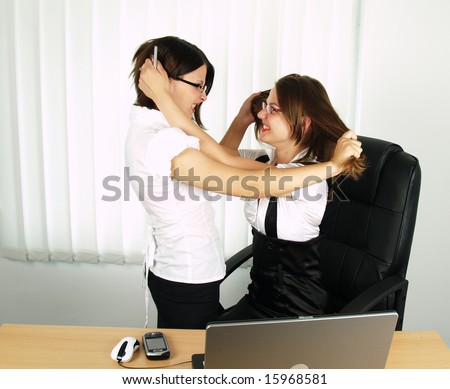 two attractive business woman fighting in office