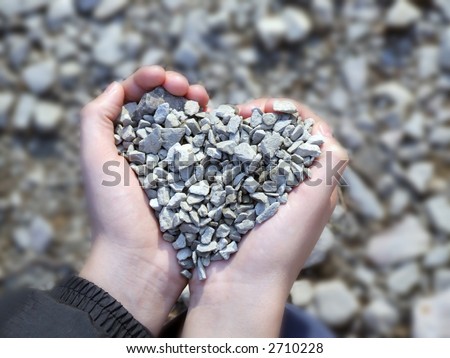 Child hands holding stones in heart shape