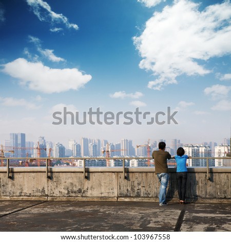 couple of lover looking at city building and thinks about the future