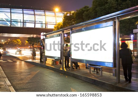 Night bus station with blank billboard
