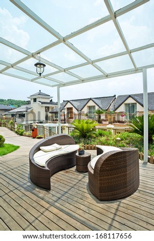 Home exterior patio with wooden decking and rattan sofa