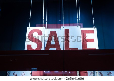 sale poster in fashion shop display window