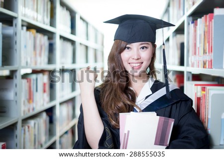 Asian beautiful female student holding book in library