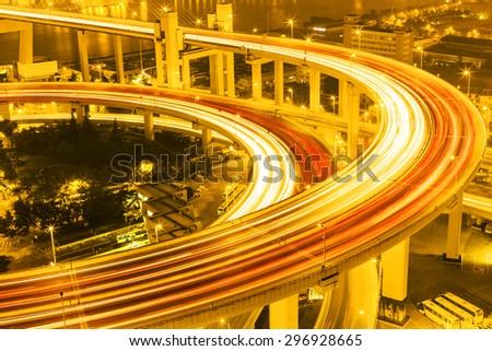 illuminated road intersection and traffic trails