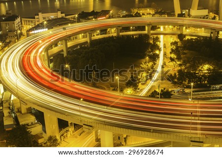 illuminated road intersection and traffic trails