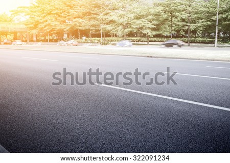 empty asphalt road in modern city with green belt