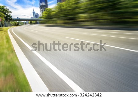 empty asphalt road in modern city with green belt
