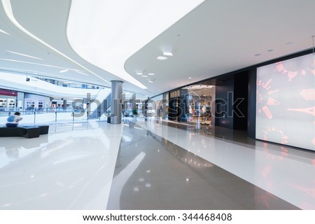 empty hallway with a huge billboard and abstract ceiling in modern shopping mall