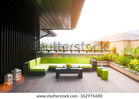 elegant bench and table on wooden floor outside house with sunbeam