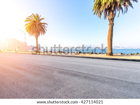 asphalt road near sea with cityscape and skyline of san francisco