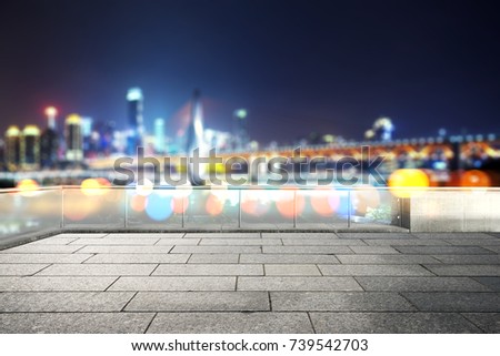 empty marble floor and blur view of modern suspension bridge and cityscape of chongqing at night