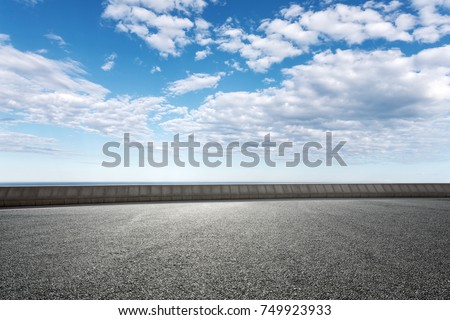 empty asphalt road and beautiful sea in blue cloud sky