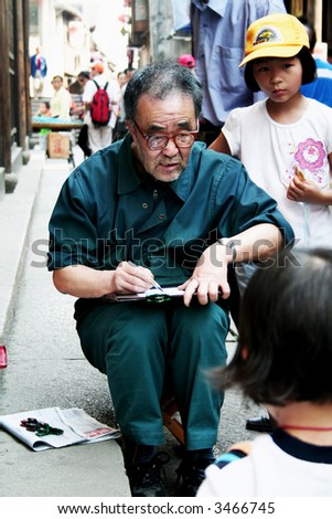 old man drawing in street