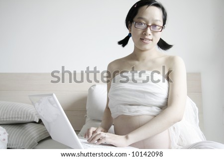 pregnant women with pc on bed