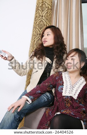 two women watch TV at home