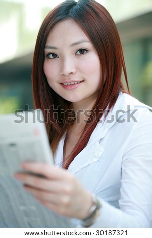 young asian businesswomen reading newspaper