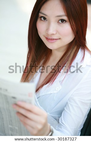 young asian businesswomen reading newspaper