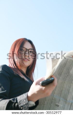young asian businesswoman reading newspaper