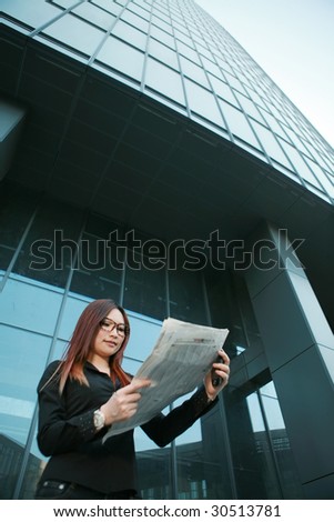 young asian business woman reading newspaper