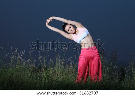 young asian woman YOGA outside at night