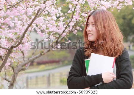 asia girl holding book with pink peach blossom