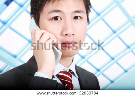 a businessman is standing  in office and answering the phone