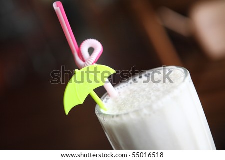 a glass of milk drink and a straw