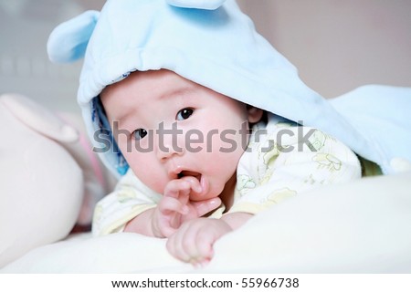 Cute little baby in bed, wearing a blue cartoon clothes
