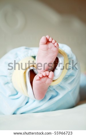 Cute little baby lying in his bed, stretched out feet