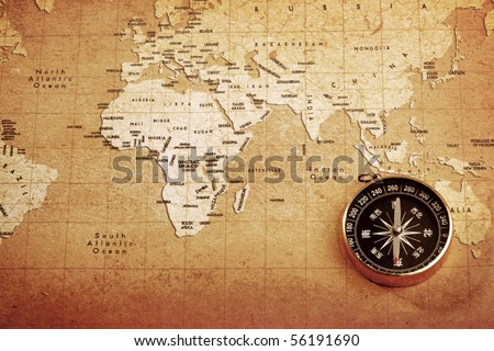 An old brass compass on a Treasure map background