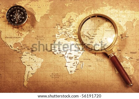 An old brass compass on a Treasure map background ,with Magnifier