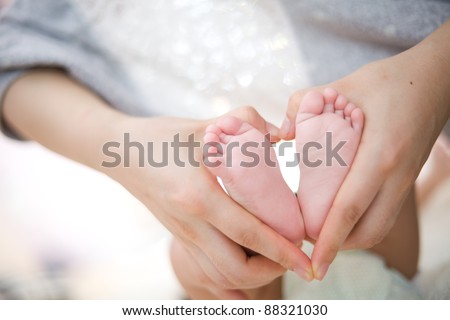 hold baby\'s foot as love heart shape