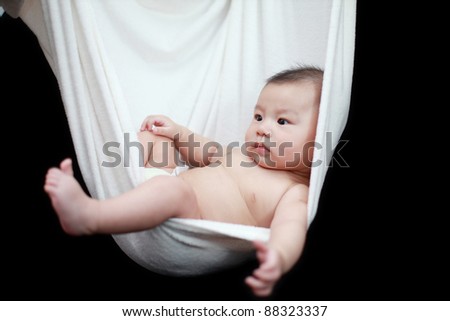 Naked Baby sleeping in White Hammock Sling, isolated on a black background.