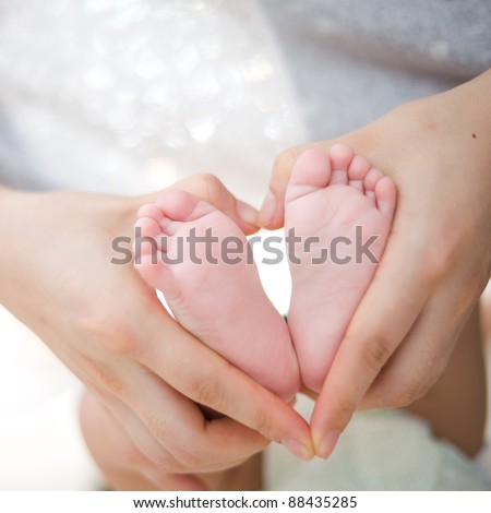 hold baby\'s foot as love heart shape