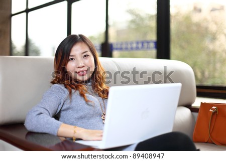 Smiling asian business woman with laptop