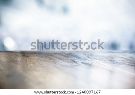 BLANK WOODEN TABLE DESK TOP ON COLD LIGHT WINTER BACKGROUND, BACKDROP FOR FOOD AND DRINKS