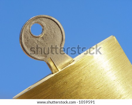 Close-up of padlock with key against clear blue sky