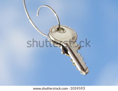 Close-up of hanging  key against clear blue sky with clouds
