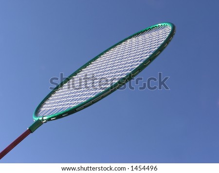 Close-up of badminton racket against blue sky background