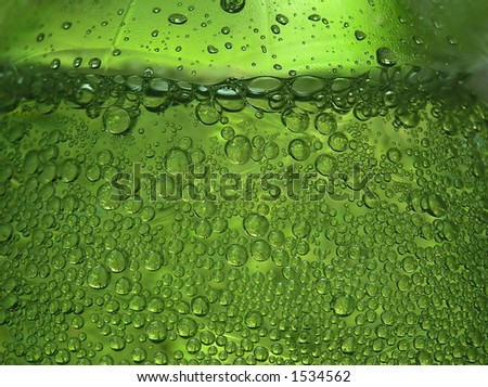 Close-up of water bottle with sparkling drops and a green impression
