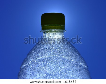 Bottle of water with lots of drops and blue sky as background