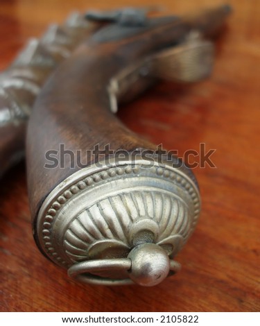 Close-up of old gun stock with decorations on brown background