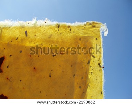 Yellow handmade structured paper against blue sky