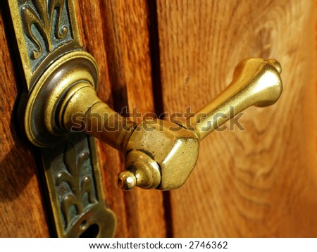 Close-up of metallic door handle on an old wooden door