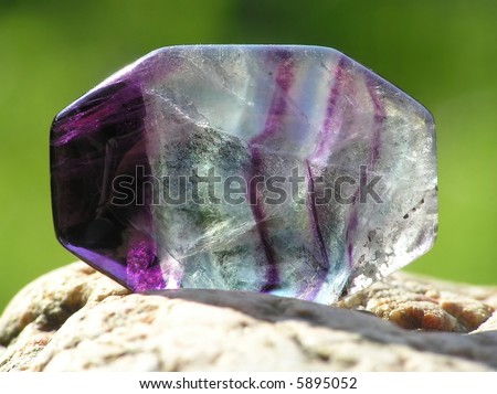 close-up of transparent amethyst placed on a rock