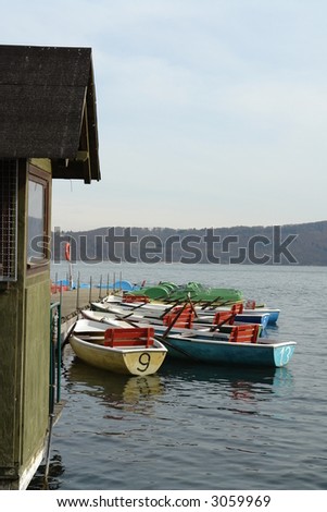 Different brightly colored rental boats at a large lake