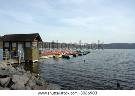 Different brightly colored rental boats at a large lake